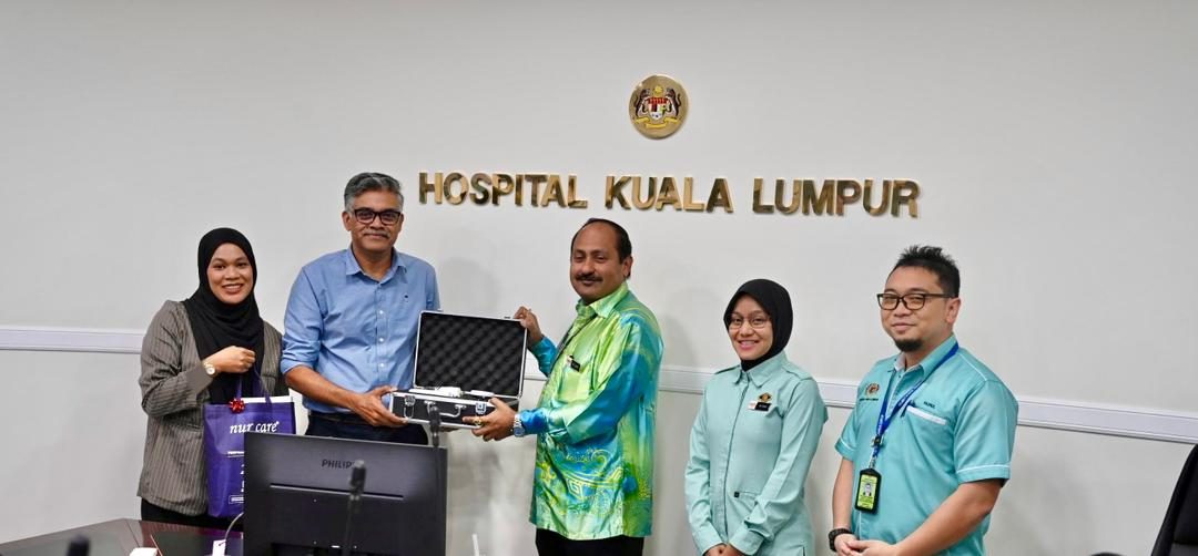 Teepham staff handing over an instrument case at Hospital Kuala Lumpur