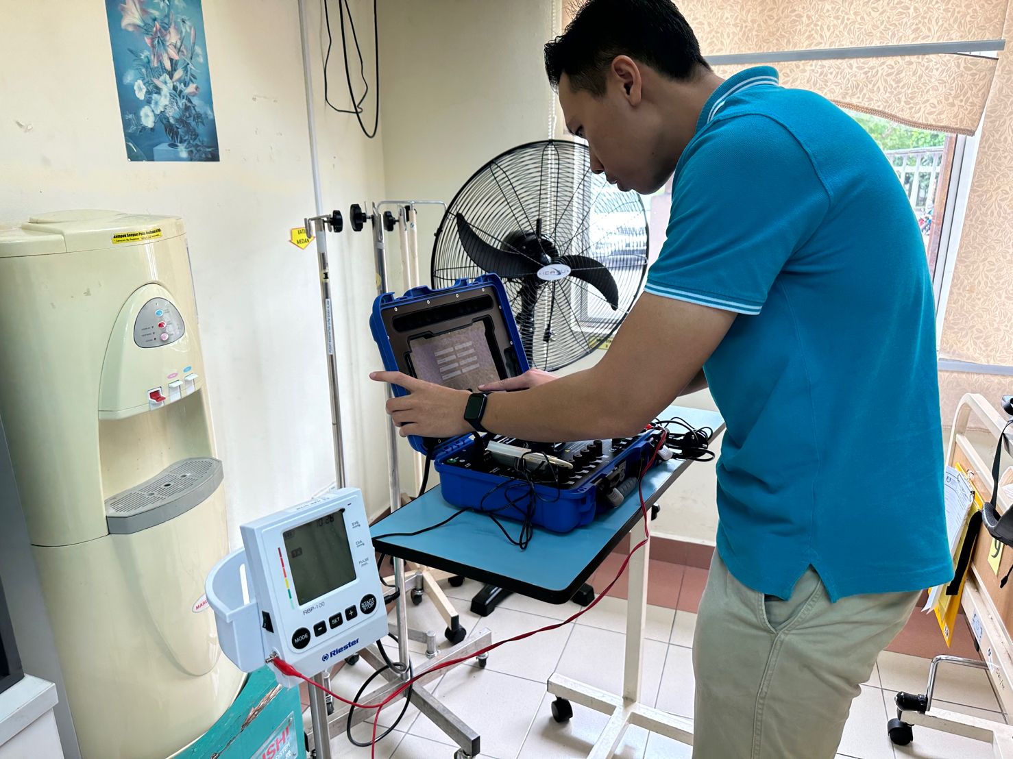 A Teepham technician calibrating a Riester blood pressure monitor with a test unit at a clinic